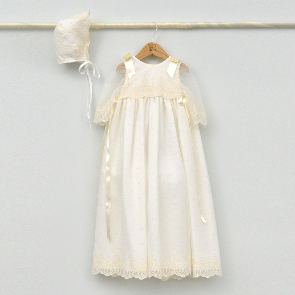 Faldón de bautizo largo en color crema con detalles de encaje y capota a juego, hecho artesanalmente en España