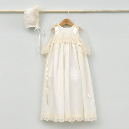 Faldón de bautizo largo en color crema con detalles de encaje y capota a juego, hecho artesanalmente en España