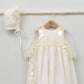 Faldón de bautizo largo en color crema con detalles de encaje y capota a juego, hecho artesanalmente en España